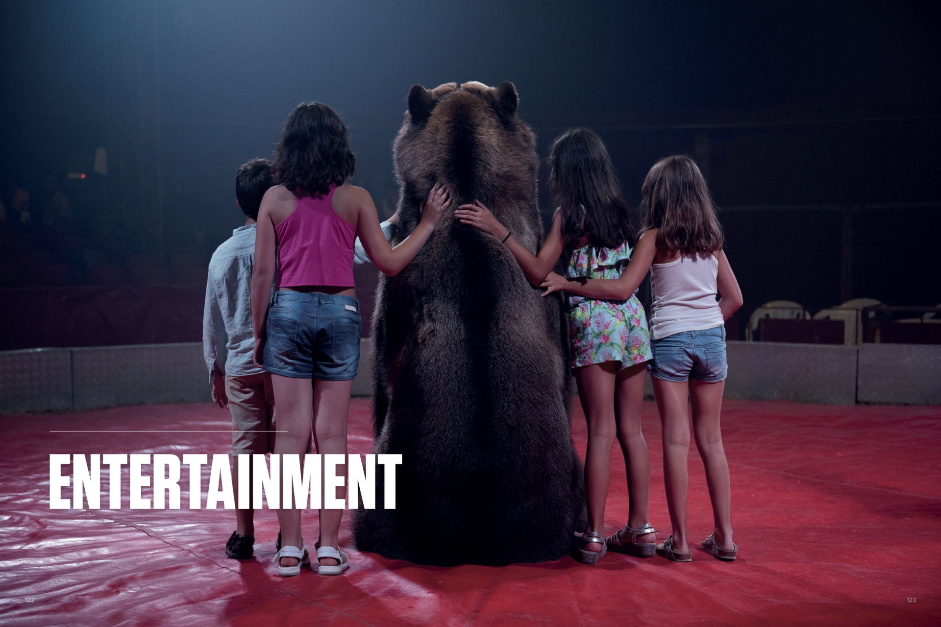 Tima the brown bear of the Gran Circo Holiday circus poses for a photo with children. Spain. Aitor Garmendia