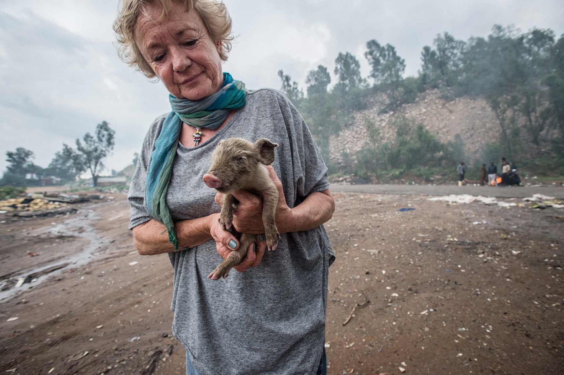 Cora Bailey, founder of Community Led Animal Welfare (CLAW), rescuing a piglet at the Randfontein Dump in Johanessburg. South Africa, 2016